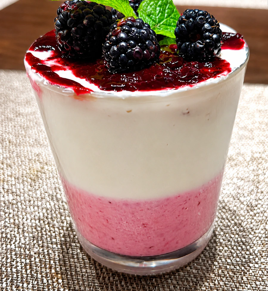 Blackberry parfait in a glass with mint and berry sauce